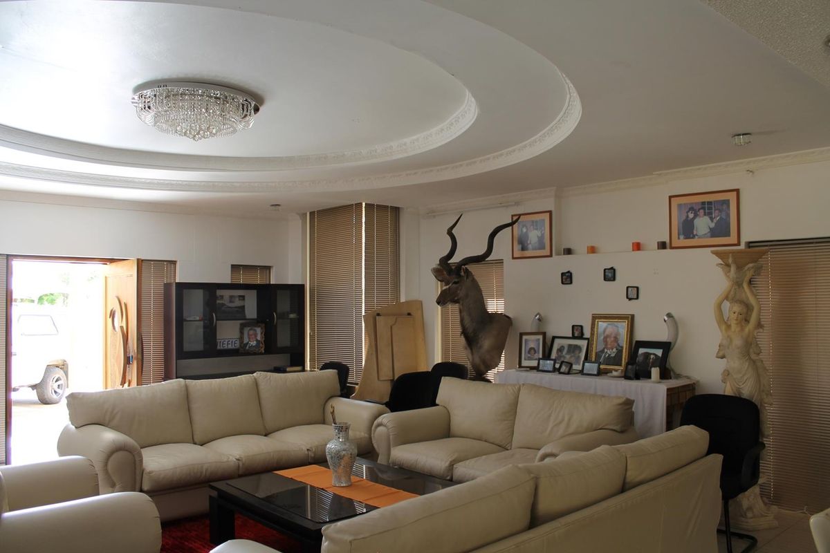 Spacious living room featuring a distinctive circular recessed ceiling design with decorative molding and integrated lighting.