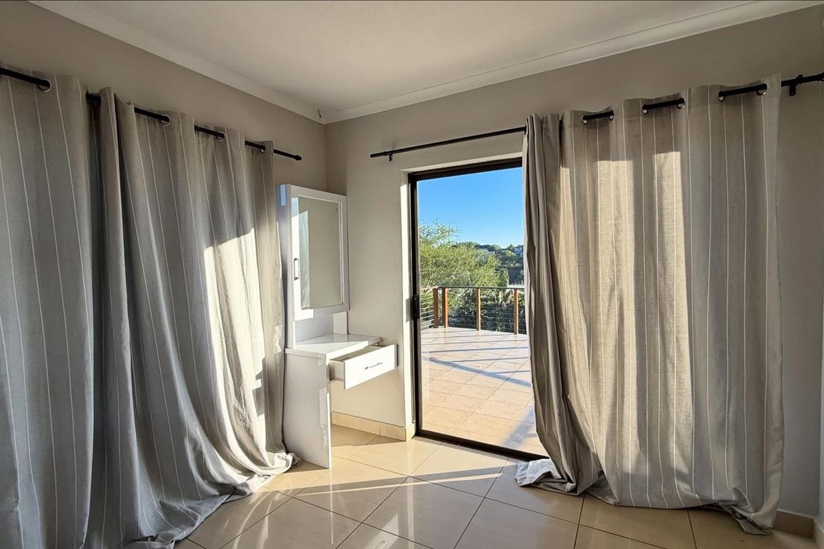 Bright bedroom featuring tiled flooring and a sliding glass door providing direct access to an outdoor balcony.