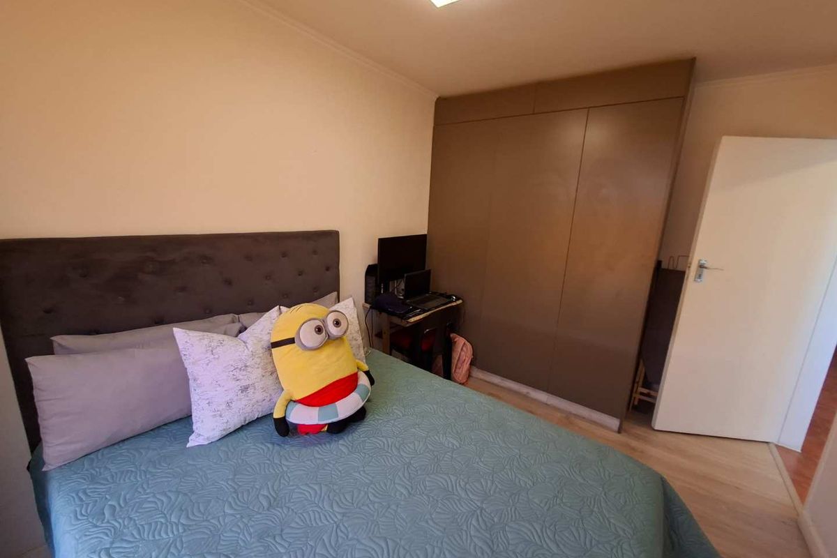 A bedroom featuring laminate flooring, a built-in wardrobe, and a flush mount ceiling light.