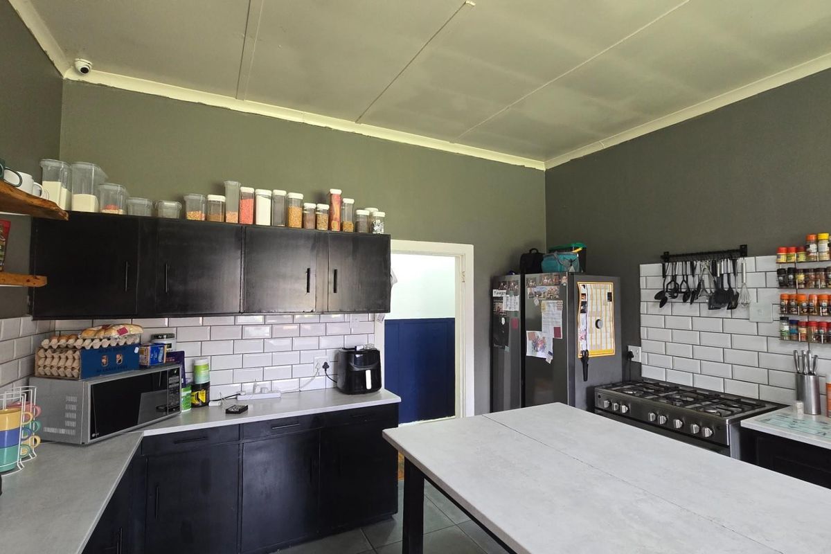 A functional kitchen featuring dark cabinetry, white subway tile backsplashes, a gas hob, and a central island workspace.