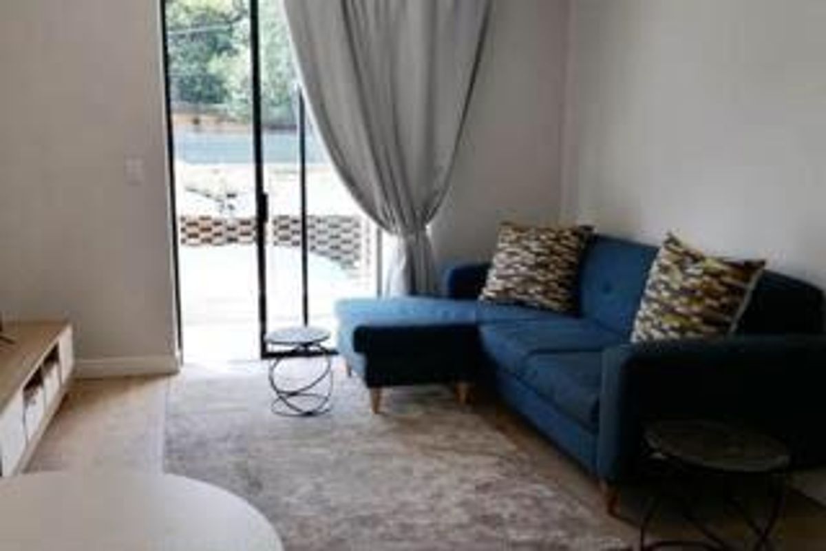 A comfortable living room featuring large sliding glass doors that provide natural light and direct access to the outdoor patio area.