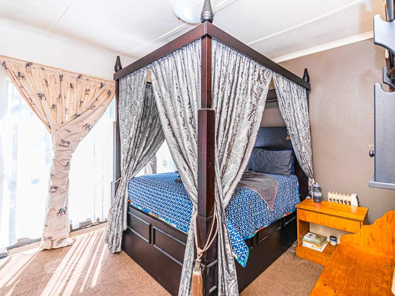 A bedroom featuring carpeted flooring and a sliding glass door providing natural light.