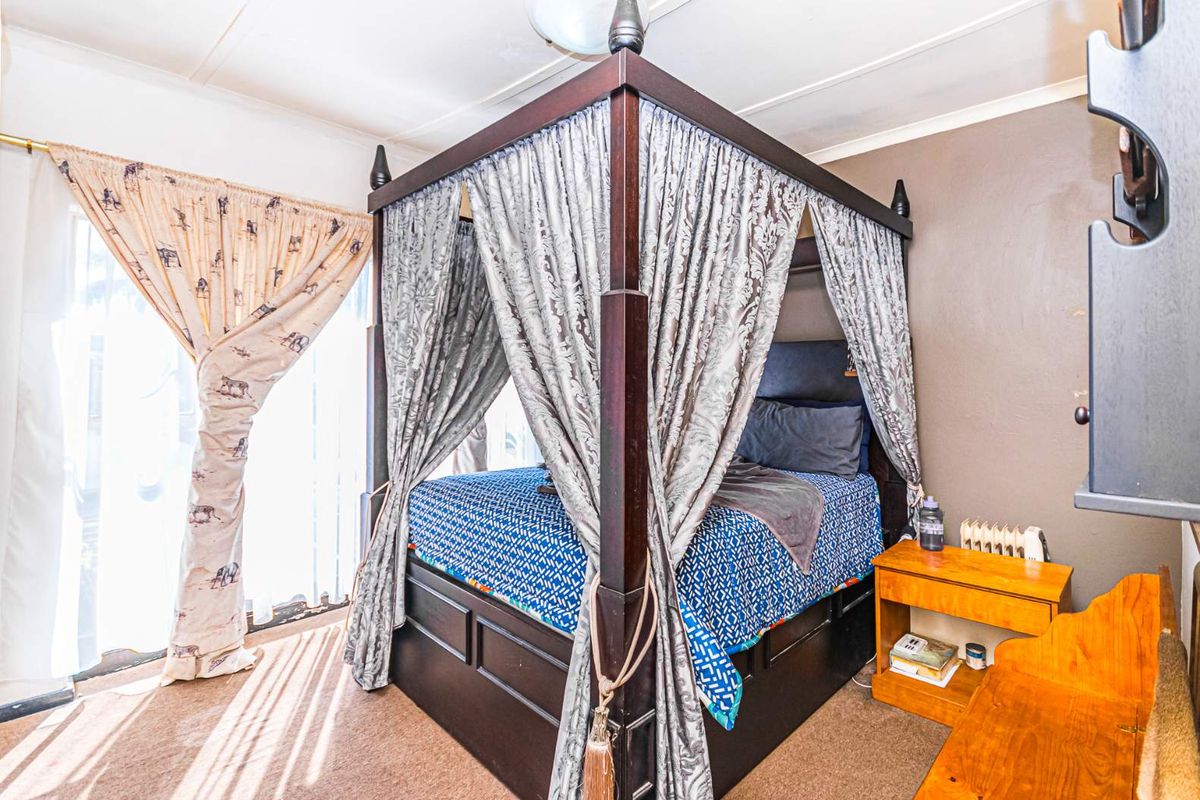 A bedroom featuring carpeted flooring and a sliding glass door providing natural light.