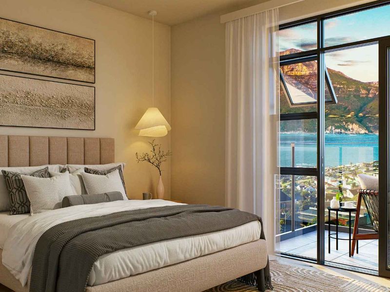 A modern bedroom featuring a large sliding glass door that opens onto a balcony with stunning coastal and mountain views.