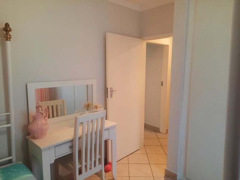 A bedroom featuring tiled flooring and access to an adjoining hallway through a standard internal door.