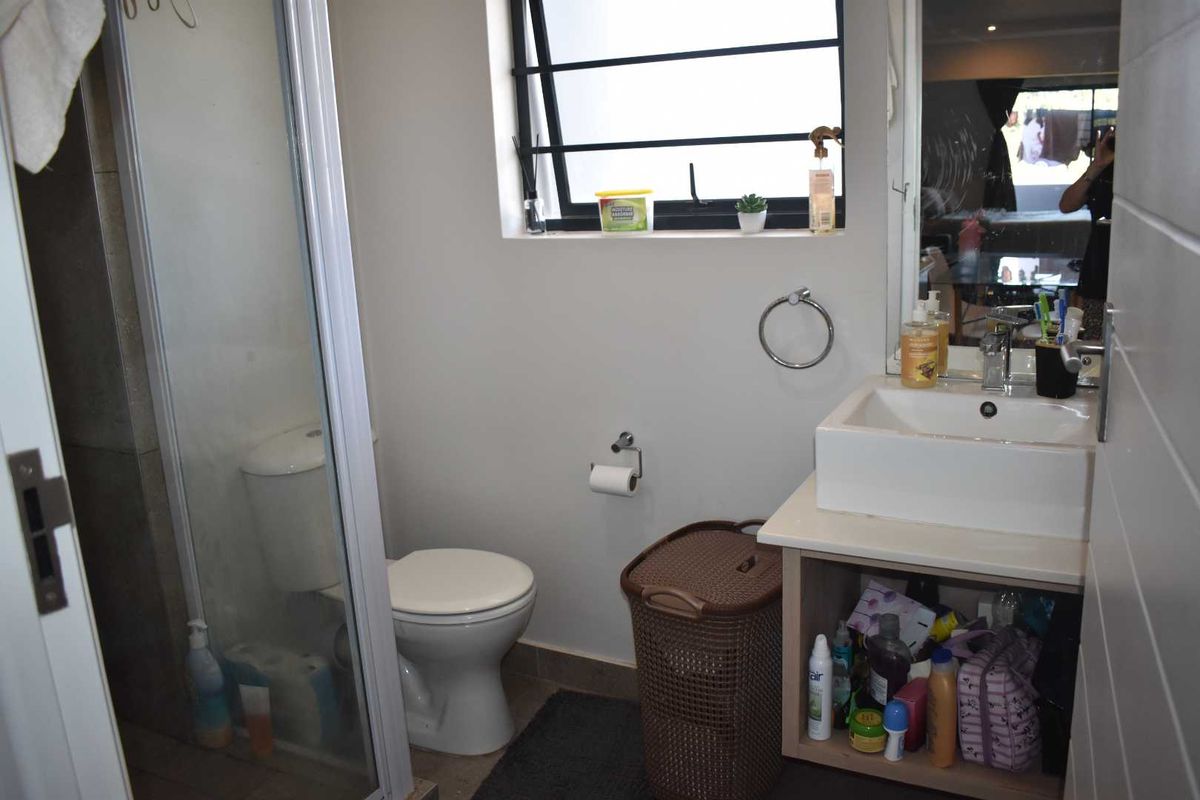 Compact bathroom featuring a glass-enclosed shower, a modern vessel sink vanity, and a window for natural light.