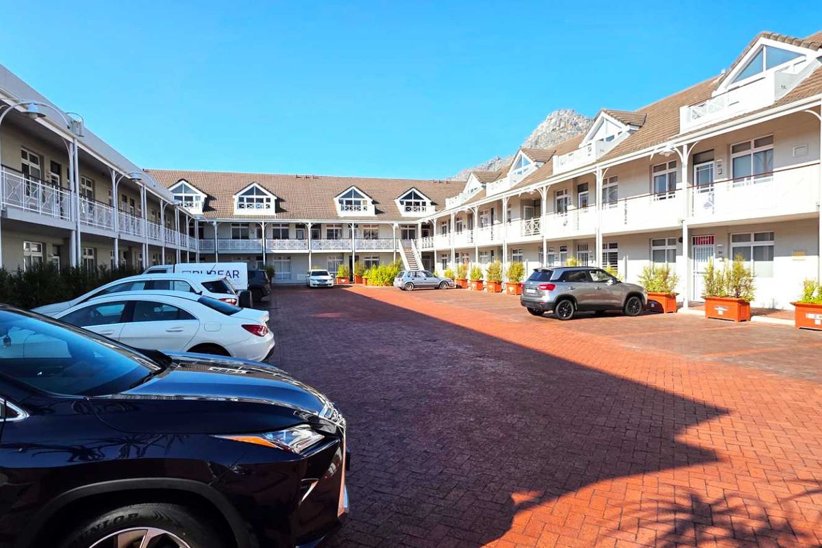 A view of the office complex courtyard featuring paved parking areas and multi-level building facades with balcony access.