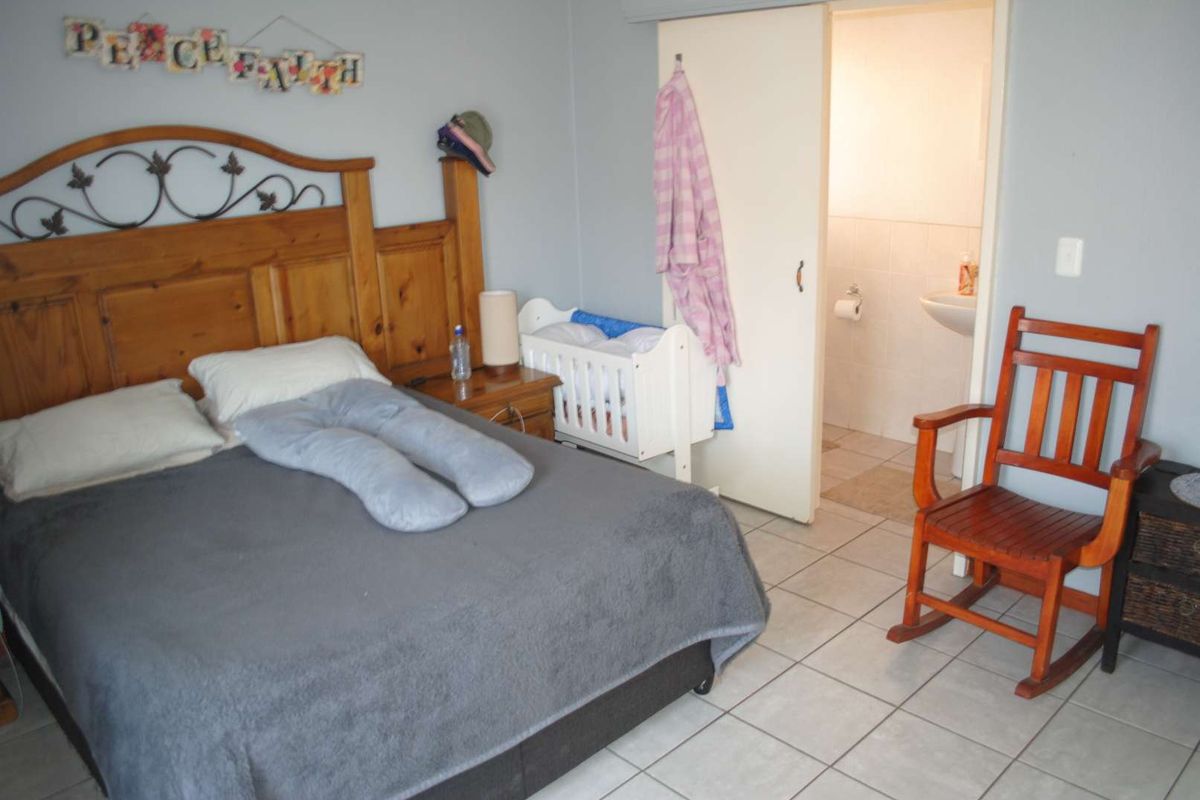 A bedroom featuring tiled flooring and an en-suite bathroom access, providing a functional layout for comfortable living.