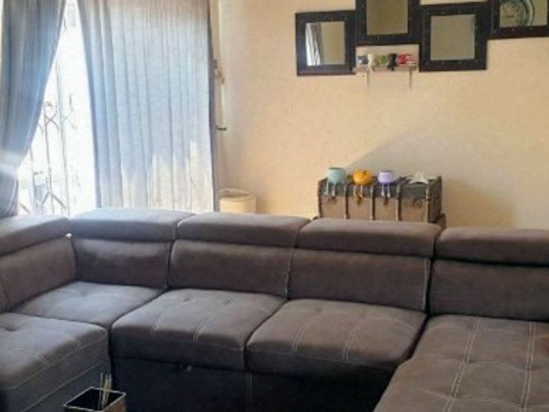A living room area featuring a sliding door with an integrated security gate, providing access to the exterior.