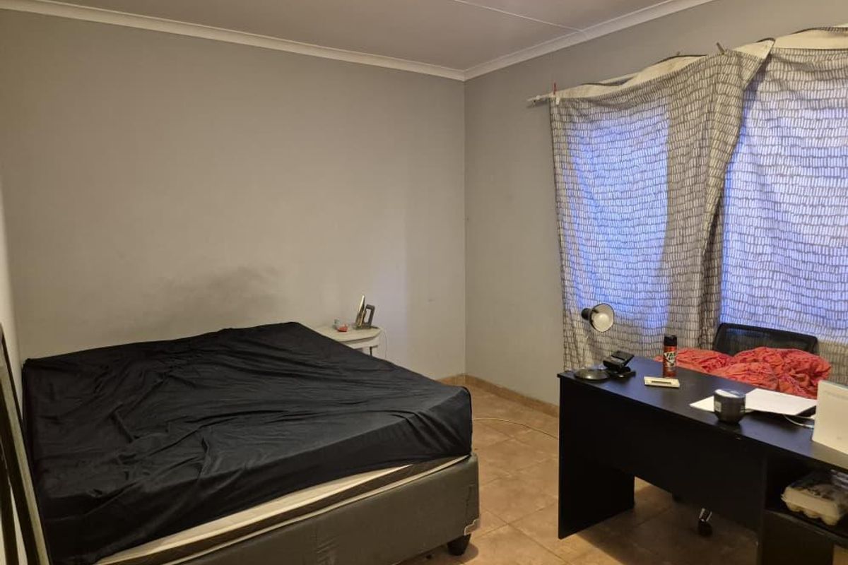 A bedroom featuring tiled flooring and neutral wall finishes, offering a functional space ready for personalization and cosmetic updates.