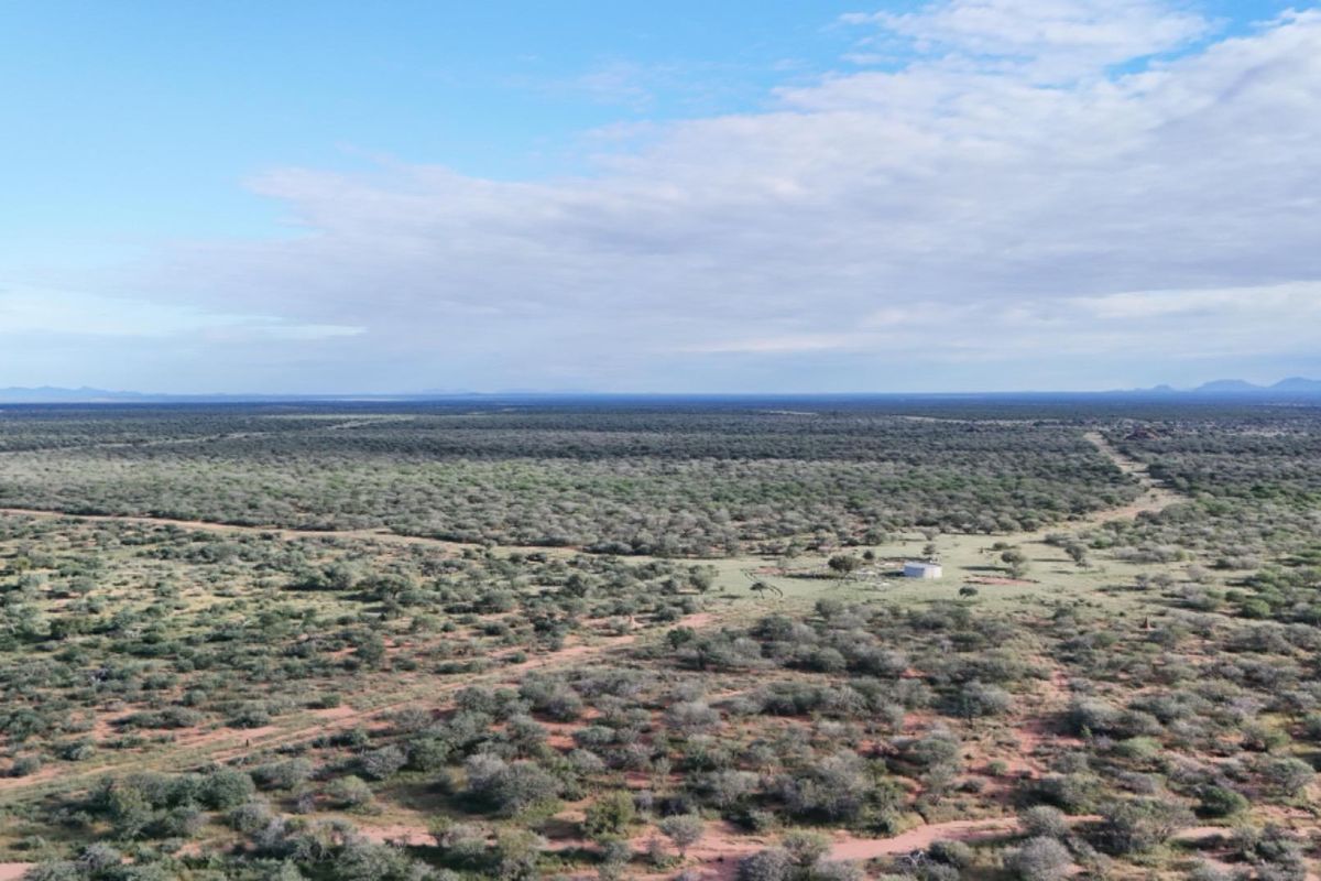 An expansive aerial view of the farm landscape, showcasing the vast natural terrain and open space surrounding the property.