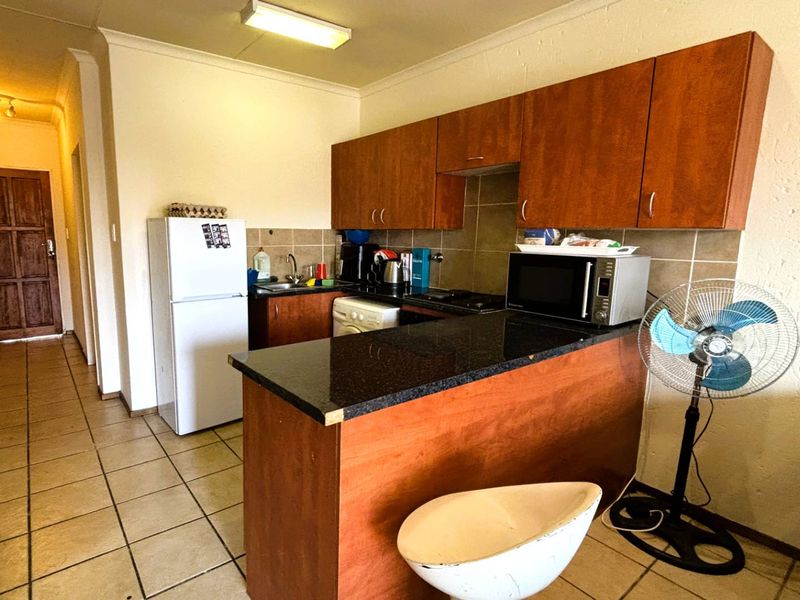 Functional kitchen featuring laminate cabinetry, granite countertops, tiled backsplash, and integrated cooking appliances, offering a practical layout for daily meal preparation.