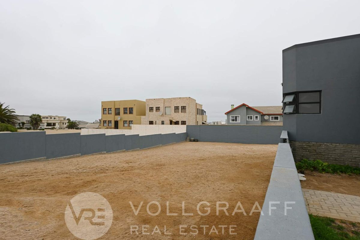 A spacious, undeveloped rear yard area enclosed by perimeter boundary walls, offering a blank canvas for landscaping or outdoor development.