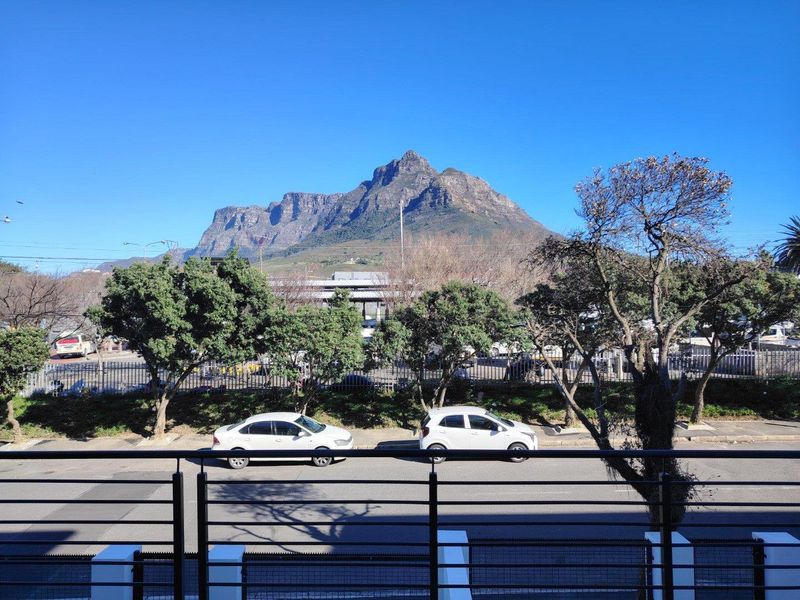 A clear, elevated view of the mountain landscape captured from a balcony with a modern metal balustrade.