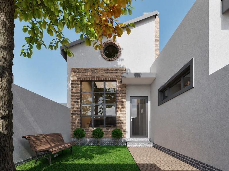 A modern townhouse rear exterior featuring a brick and render facade, a circular window, and a paved walkway leading to the entrance.