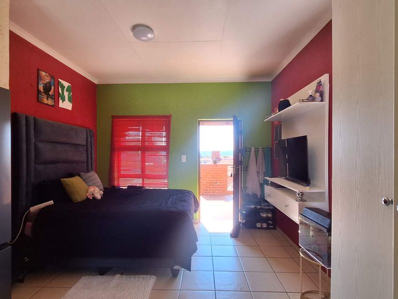 Bedroom featuring tiled flooring, built-in shelving, and direct access to an outdoor balcony area.