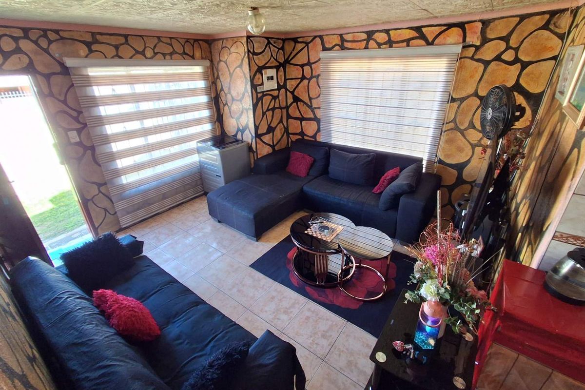 Living room featuring tiled flooring, textured ceiling, and roller blinds, with a distinctive decorative wall finish.
