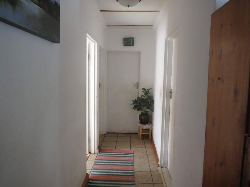 A functional hallway featuring tiled flooring and multiple doorways providing access to various rooms within the home.