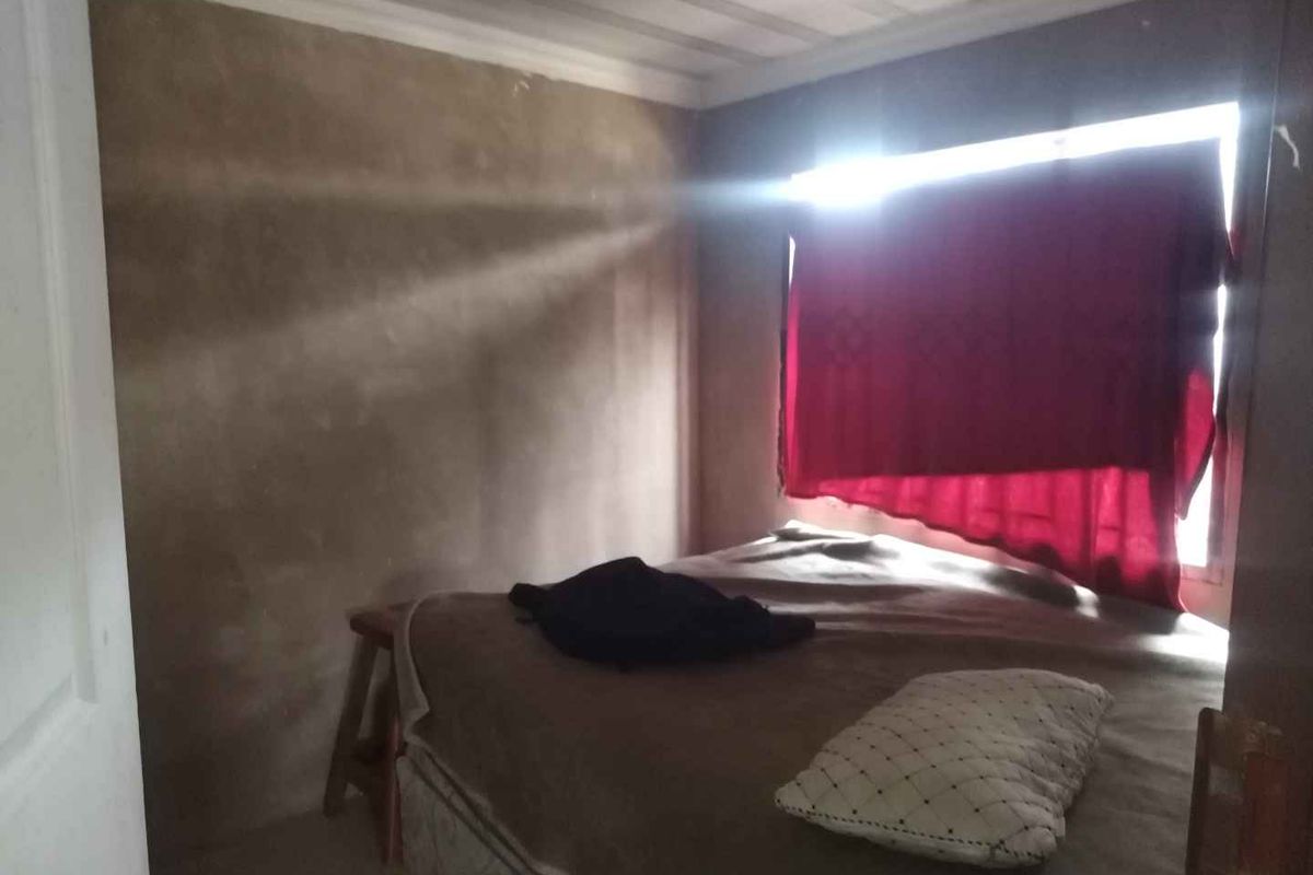A bedroom featuring a timber ceiling and unfinished wall surfaces, requiring cosmetic updates to improve the overall finish and aesthetic appeal.