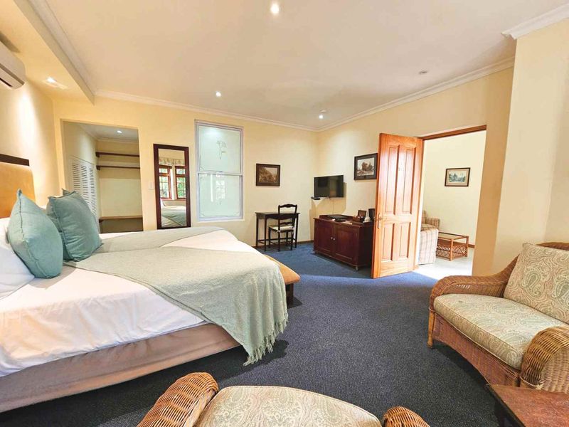 Spacious bedroom featuring neutral walls, blue carpeting, recessed lighting, and an integrated closet space with an adjoining room access.