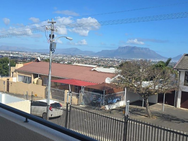 Elevated view overlooking the surrounding residential neighborhood with distant mountain scenery.