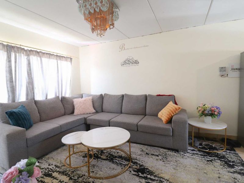 A living room area featuring a large window and tiled ceiling, requiring cosmetic updates to improve the overall finish and aesthetic appeal.