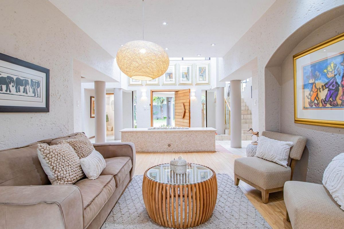 Spacious living area featuring textured walls, architectural columns, and a central built-in feature, leading towards an open entrance with natural light.