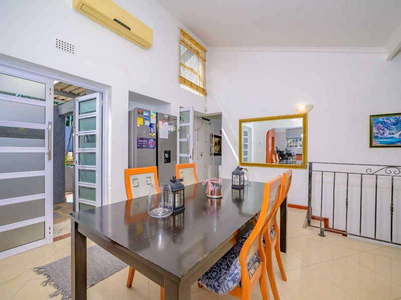 Dining area featuring tiled flooring, a wrought iron balustrade, and direct access to an outdoor patio through a glass panelled door.