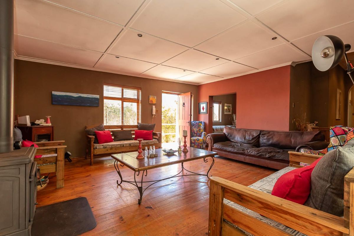 Spacious living room featuring warm timber flooring, a built-in wood-burning fireplace, and direct access to the exterior.