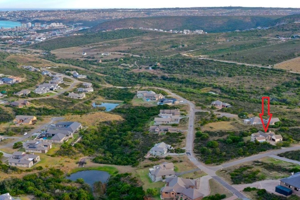 An aerial view of a residential estate situated in a coastal landscape, highlighting the property location and surrounding neighborhood infrastructure.