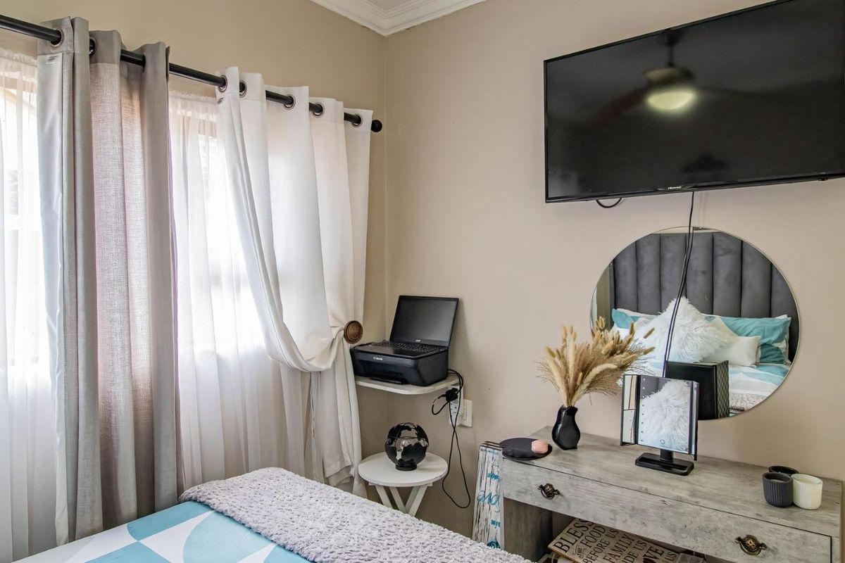 A well-maintained bedroom featuring neutral wall tones, a ceiling fan, and decorative coving, providing a comfortable and functional living space.