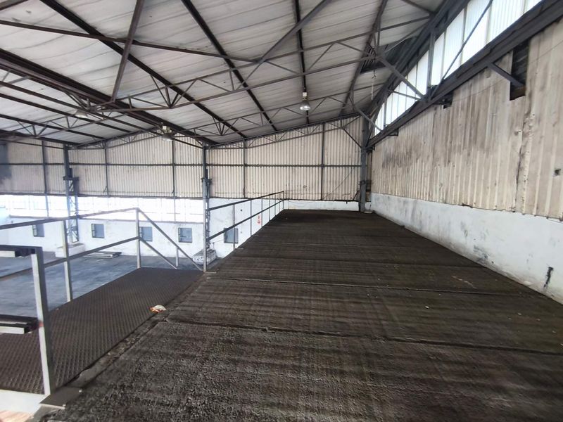 Industrial mezzanine level featuring steel flooring, metal cladding, and structural roof trusses, suitable for storage or additional workspace within the warehouse facility.