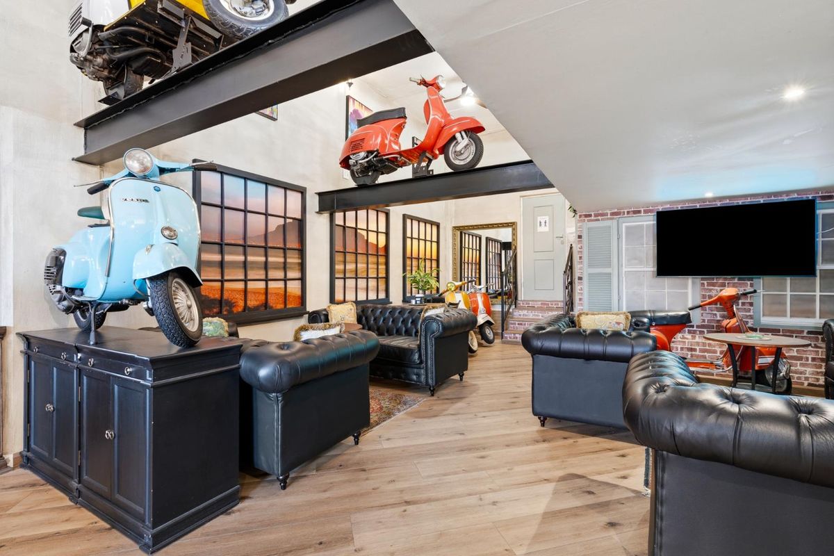 Spacious living area featuring industrial-style exposed steel beams, laminate flooring, and decorative brick accents, creating a unique and character-filled retail or lounge space.