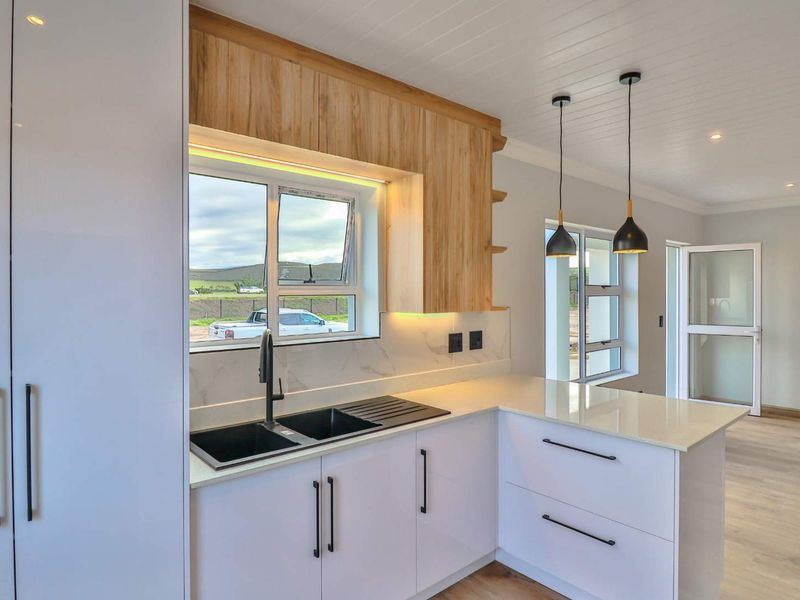 Modern kitchen featuring white cabinetry, timber-look accents, quartz countertops, and high-quality finishes, creating a bright and functional culinary space.