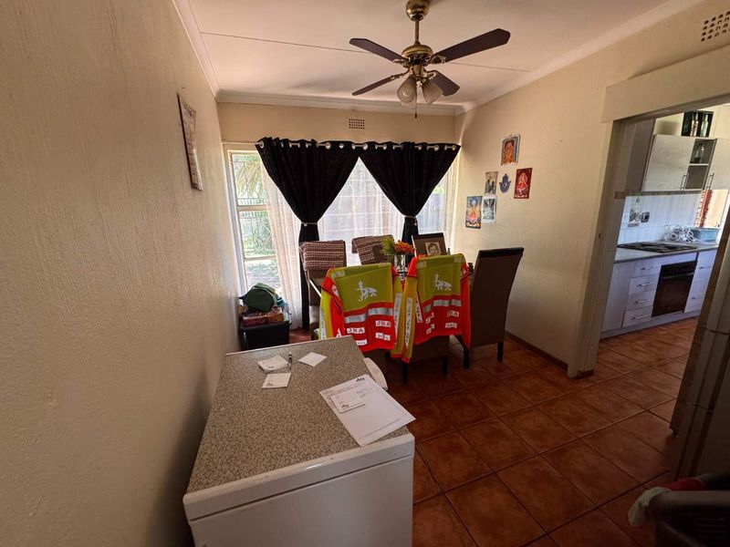 Dining area featuring tiled flooring, a ceiling fan, and direct access to the exterior through a sliding glass door.