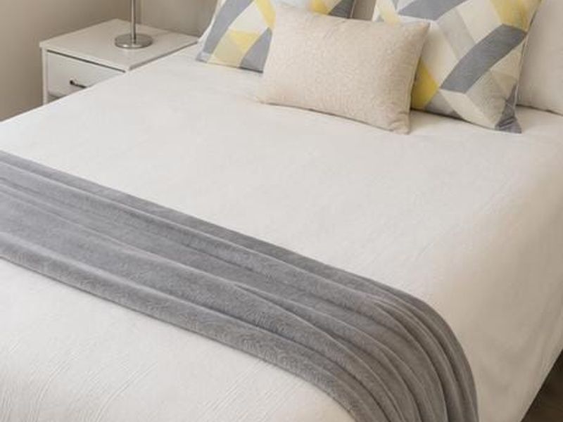 A well-presented bedroom featuring neutral wall finishes and light-toned flooring.