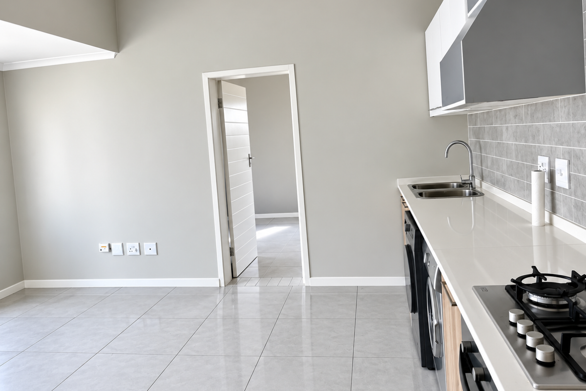 Modern kitchen featuring sleek cabinetry, stone countertops, gas hob, built-in oven, and neutral tiled flooring, offering a clean and functional culinary space.