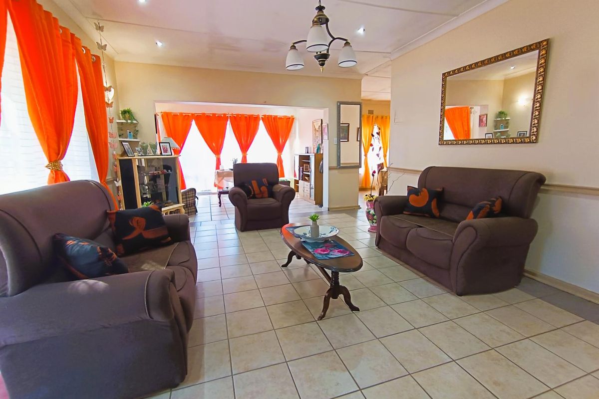 Spacious living area featuring tiled flooring and a neutral color palette, providing a comfortable and functional space for relaxation.