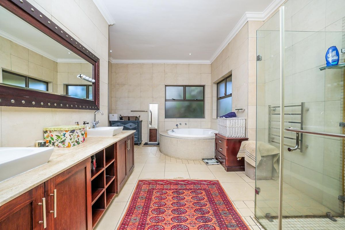 Spacious bathroom featuring a double vanity with vessel sinks, a built-in corner soaking tub, and a separate glass-enclosed shower with tiled finishes.