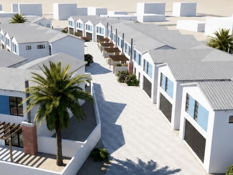 Aerial view of a modern townhouse development featuring uniform architectural design, paved driveways, and integrated garage access near the coast.