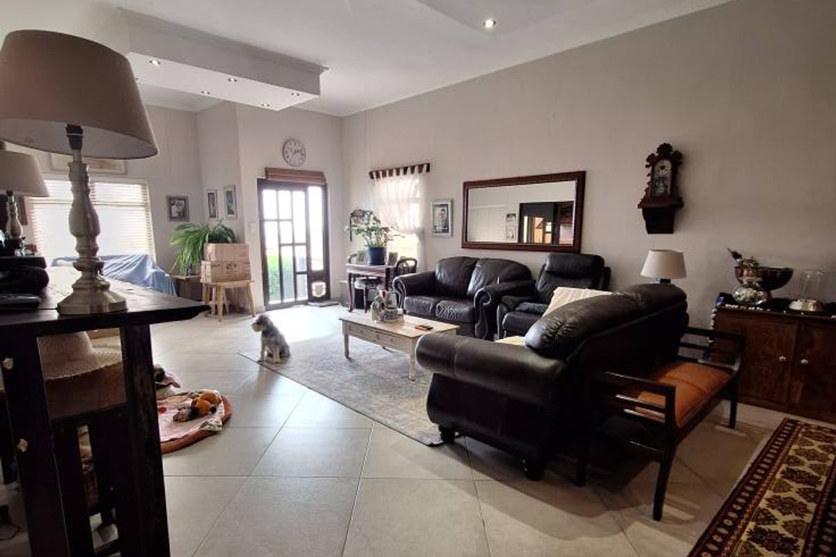 Spacious living area featuring tiled flooring and a modern recessed ceiling design with integrated downlighting.