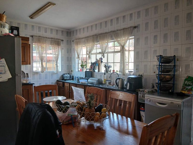 A functional kitchen featuring built-in cabinetry, laminate countertops, and a tiled backsplash, offering potential for modernization and aesthetic updates.