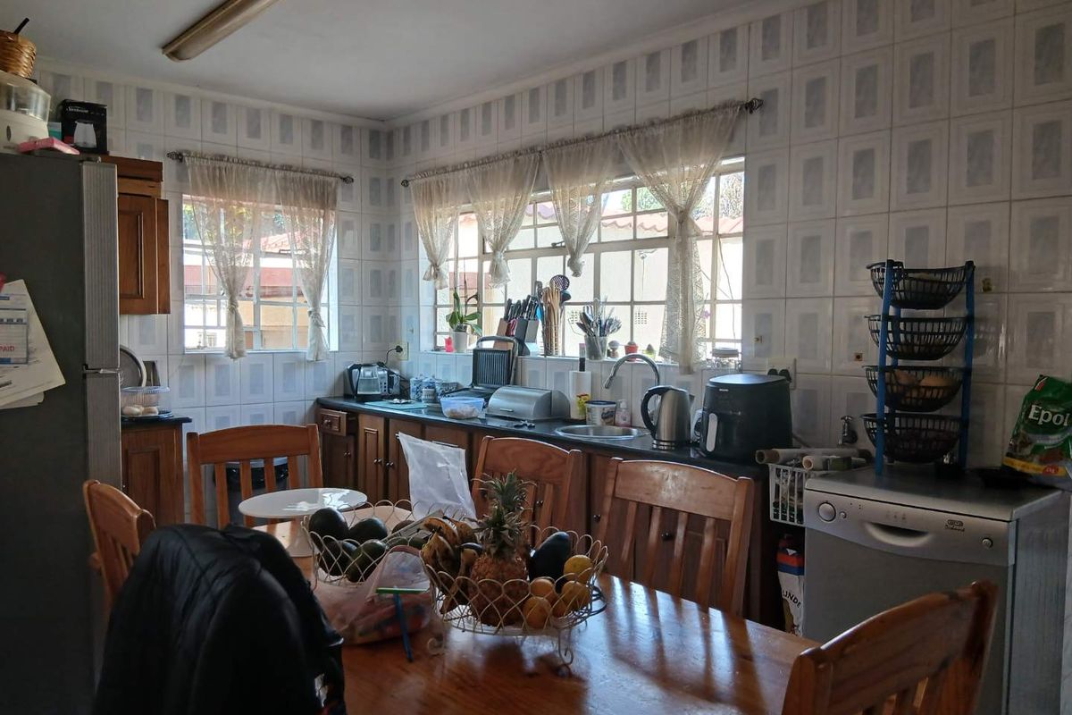 A functional kitchen featuring built-in cabinetry, laminate countertops, and a tiled backsplash, offering potential for modernization and aesthetic updates.