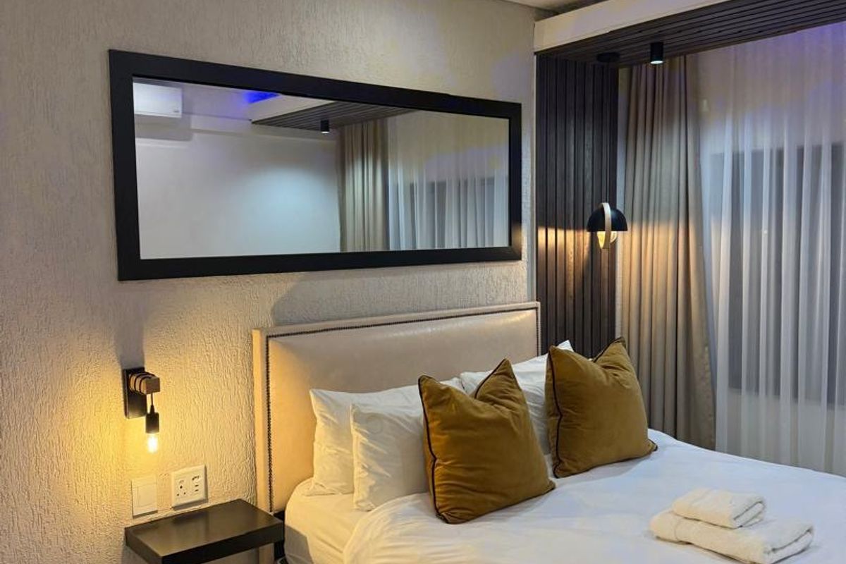 Modern bedroom featuring textured wall finishes, slatted wood accents, recessed and LED strip lighting, and a floating bedside shelf.