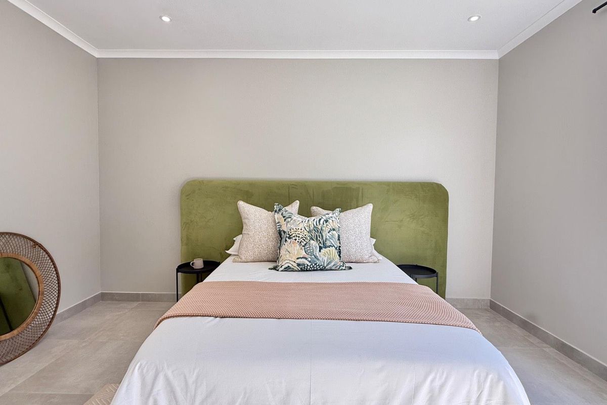 A well-maintained bedroom featuring neutral wall tones, modern tiled flooring, and recessed ceiling lighting, providing a clean and contemporary living space.