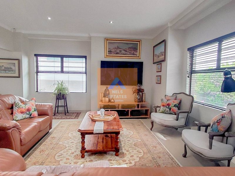 A well-maintained living room featuring recessed downlighting and venetian blinds, offering a comfortable and functional space for relaxation.