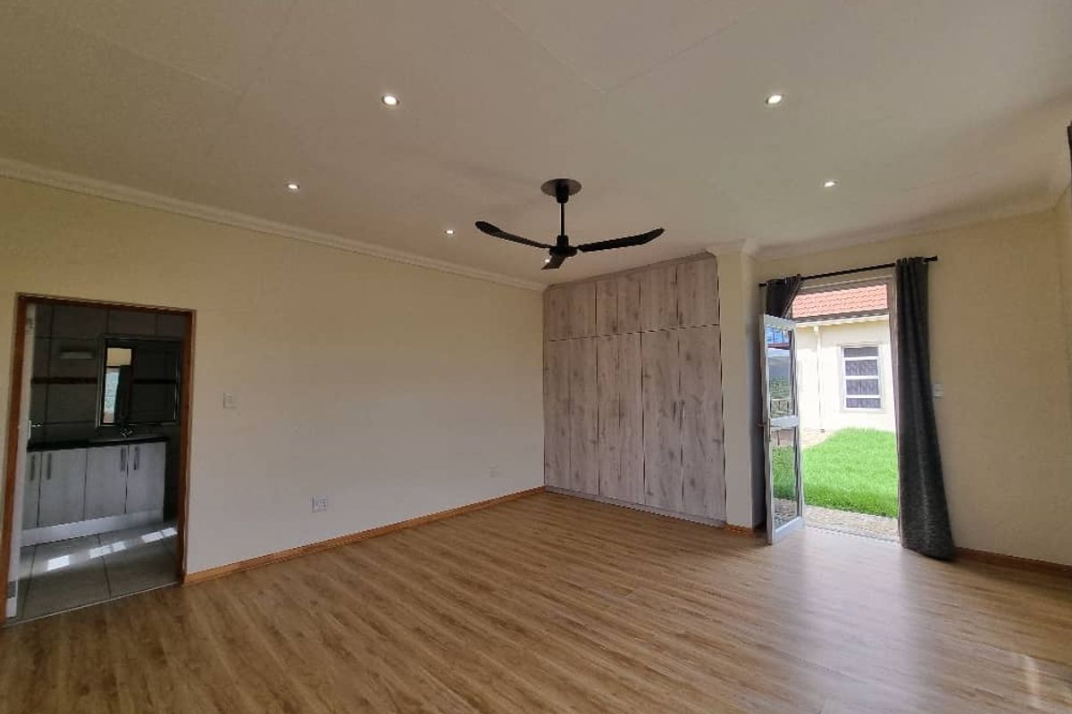 Spacious bedroom featuring wood-look flooring, built-in cupboards, recessed ceiling lighting, a ceiling fan, and direct access to the garden.