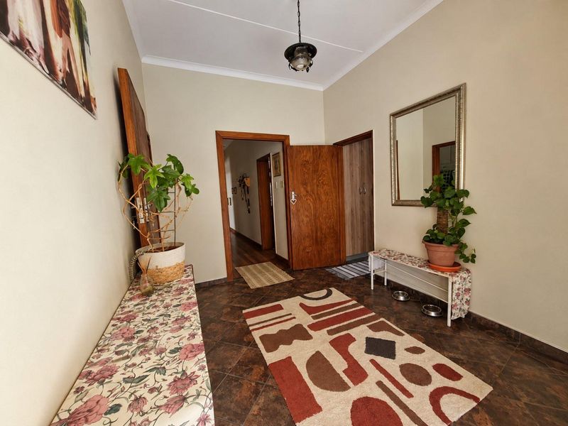 A functional hallway featuring tiled flooring, coved ceilings, and wooden door frames, providing access to multiple rooms within the home.