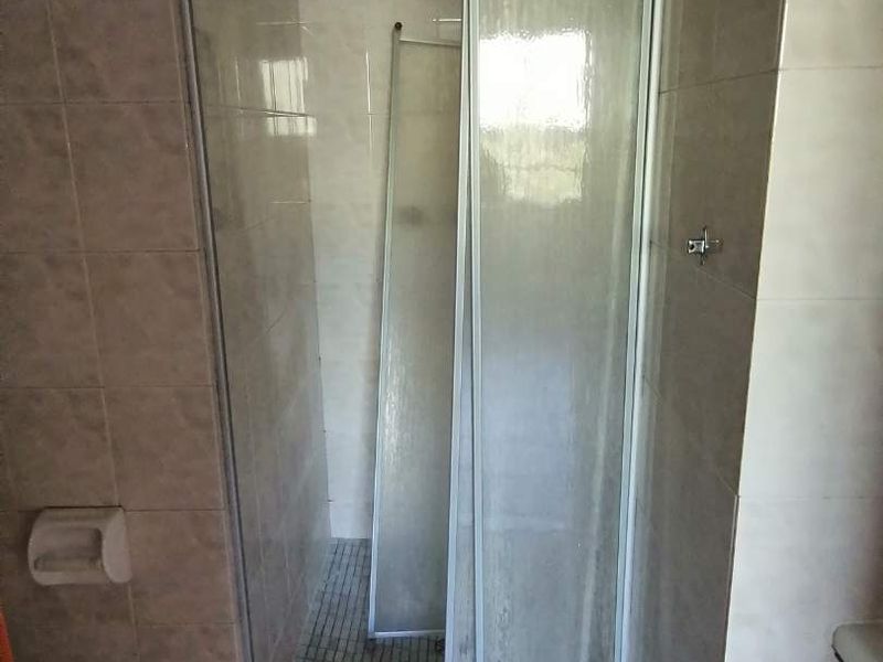 A bathroom featuring a tiled shower enclosure with a sliding glass door.