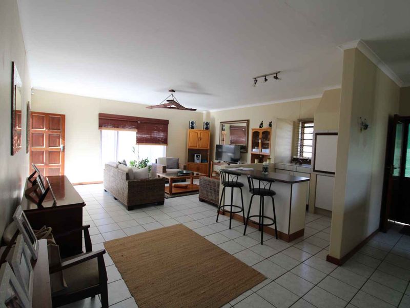 Open plan living and kitchen area featuring tiled flooring, a breakfast bar, and direct access to the exterior.